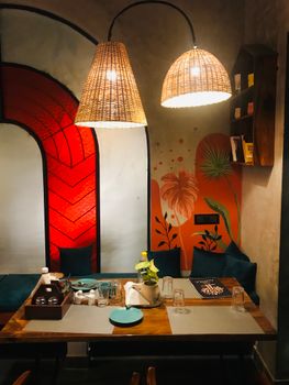 Warm and inviting restaurant setting with unique lighting and colorful mural.